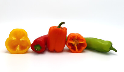 Composition of several sweet peppers and their halves of different colors on a light background. Natural product. Natural color. Close-up.