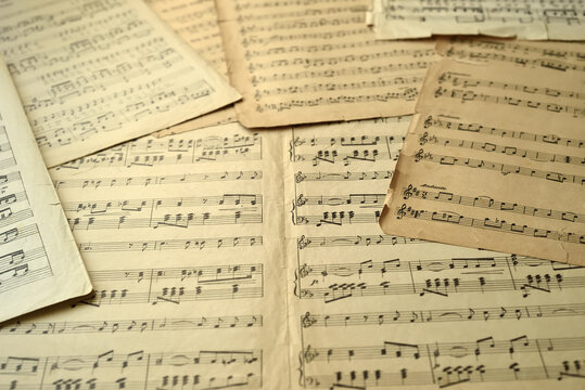 Old sheets with music notes scattered on the table. Close-up. Retro style. Selective focus.