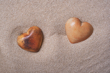 Obraz premium Two stone hearts in the sand.