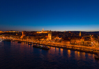 Fototapeta premium Aerial drone shot of St. Anne Parish church by Danube river at Budapest dusk city lights on