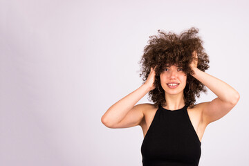 Caucasian young woman with natural Afro curly hair, close up isolated on white. Hair care concept