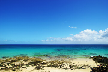 Tropical beach, azure ocean water and blue sky. Paradise landscape.