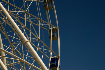 Cabin and support of a ferris wheel on a background of clear blue sky