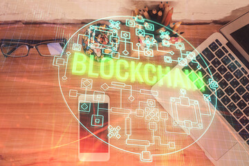Double exposure of blockchain theme hologram over table with phone. Top view. Crypto technology...