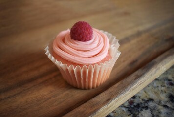 Pretty pink cupcake with raspberry garnish