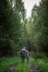 Father and son hunting together. Walking the road after the bird hunt.