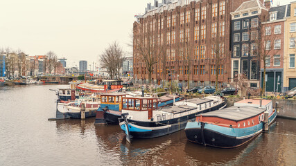 Typical floating house at Amsterdam water canal in historical center, Netherlands.