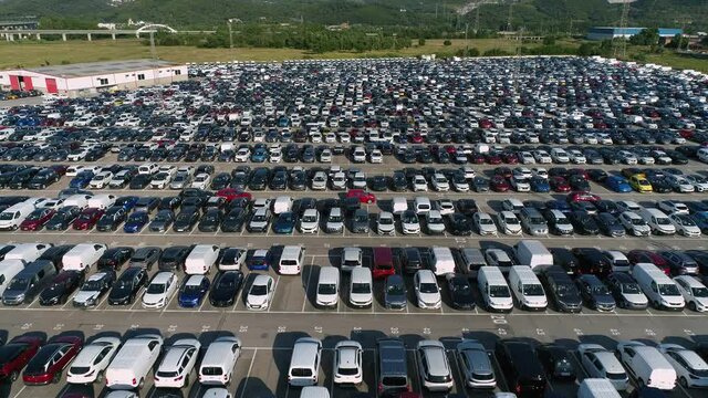 Fly back drone flies shot over huge parking lot for second hand (used) cars. Logistics transit.