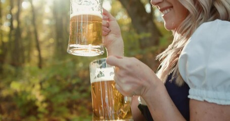 Slavic blonde has a fun, poses and clicks two glasses of beer at autumn forest