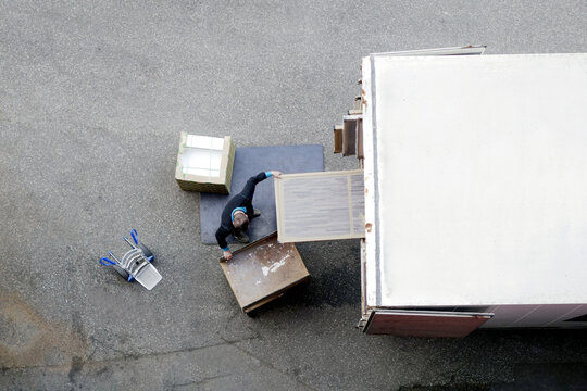 Mover Unload Furniture And Boxes From Moving Truck. Situation With Moving House Worker, Manually Download The Furniture From A Back Of A Truck. View From Above.