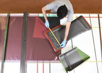 Professional worker with gloves manually realizes a component in real carbon fiber. Measurement and...