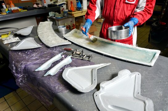 Installation Of Fiberglass: Worker Manually Realizes A Component In Glass Fiber For Automotive Use. Creating A Spoiler For Cars Using A Mold. View From Above.