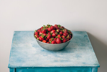Eco or Bio Strawberry in Stainless Steel Basin on Turquoise Table Front View Still-Life Shot with Natural Light