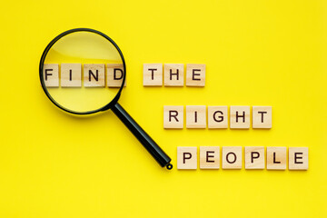 wooden block lettering find the right people and magnifying glass on yellow background. Human...