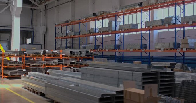 Modern warehouse for the storage of metal products. Metal products are lying on shelves in a warehouse, a large bright room at the factory.