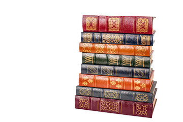 A stack of leather bound books with golden decoration isolated against a white background.