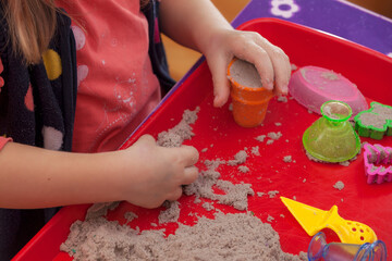 little hands playing with kinetic sand