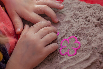 little hands playing with kinetic sand