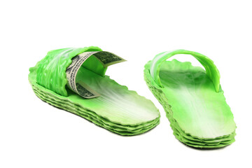 Beach rubber green sandals in the style of cabbage leaves. Dollar bill in concept. Isolated on a white background