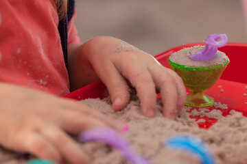 little hands playing with kinetic sand