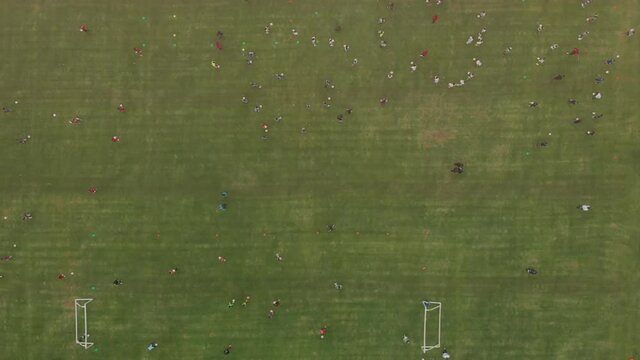 Aerial view of soccer training. Soccer field turning from above. Great soccer training ground. Many children playing soccer on top.