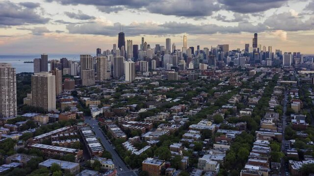 Aerial Hyper Lapse of Chicago Downtown Skyline. Modern city at sunset with dramatic clouds
