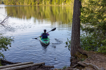 man paddling kayak on lake