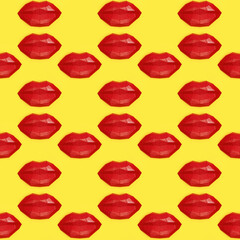 Seamless pattern with bright beauty red polygonal paper lips on yellow background.