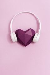 Red polygonal paper heart shape purple colored in white headphones. Music concept. Dj Headset. Minimal style.