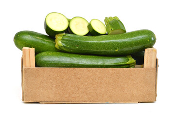 fresh zucchini's (Cucurbita pepo) in a wooden crate on a white background
