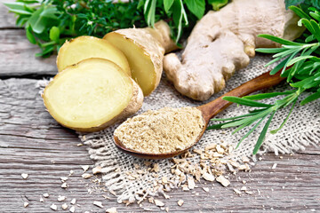 Ginger ground in spoon with root on old board