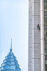 Glass cleaners hanging outside a skyscraper in Shanghai, China