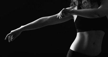 Dancing woman silhouette. Choreography class. Graceful lady with bare belly performing movements isolated on black.
