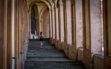 Teen in black shorts and tank top running up stairs of portico © David