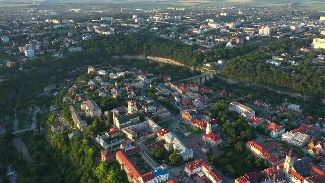 Popular tourist Ukrainian city of Kamianets-Podilskyi at dawn, aerial view. Fresh summer morning cityscape.