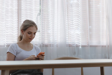 Young Caucacian woman using smartphone for texting message to lover