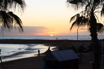 Sunset at beach and Atlantic Ocean panorama in holiday resort Playa de las Americas on Canary Island Tenerife, Spain