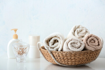 Obraz na płótnie Canvas Basket with cotton towels on table in bathroom