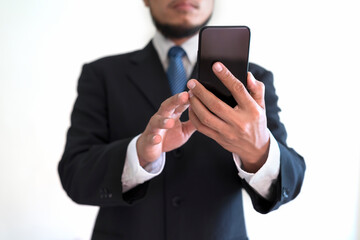 A bearded businessman holding a smartphone with a white background