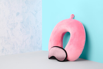 Travel pillow with sleep mask on color background