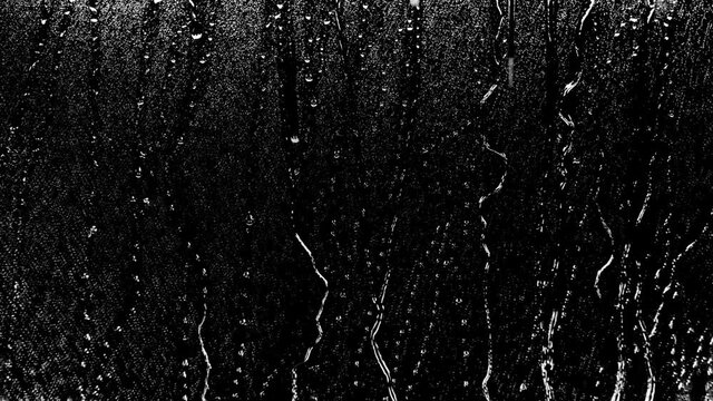 4k Rain Drops Falling down on black background, 4K High quality footage of Rain on Window Sky Drops, Close up Slow Rain, Rainy at night, Heavy Rainfall. Raining at night.