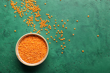 Bowl with red lentils on color background
