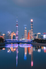 Night view of Waibaidu Bridge and Lujiazui, the skyline and landmark in Shanghai, China, with reflection in front.