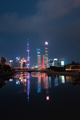Night view of Waibaidu Bridge and Lujiazui, the skyline and landmark in Shanghai, China, with reflection in front.