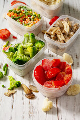 Frozen vegetables. Stocks of food for the winter. Container with frozen vegetables and mushrooms.