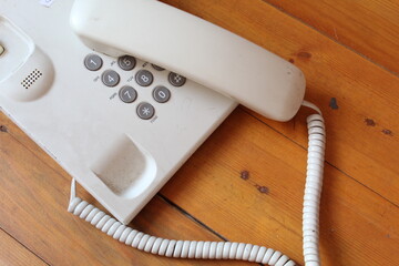 White telephone on wooden table with copy space