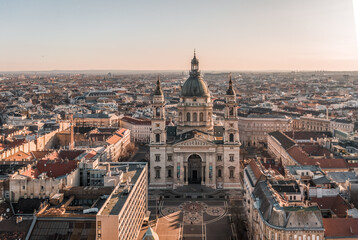 Aerial drone shot of St. Stephen's Basilica with empty square in Budapest sunrise glow
