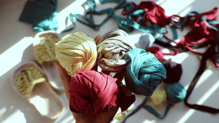 Close up from top view woman hand hold group colorful ball of yarn from recycle old t shirt