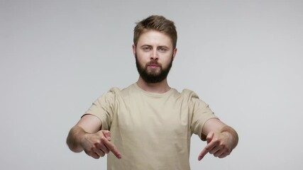 Here and right now! Bearded man pointing fingers down, demanding immediate obedience, indicating hither below, looking at camera strict authoritative. indoor studio shot isolated on gray background