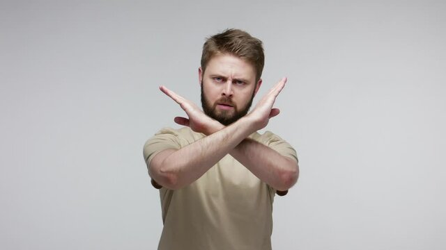 I said No! Strict bearded man crossing arms in X sign, refusal stop gesture, warning of prohibited access, declining communication, body language. indoor studio shot isolated on gray background
